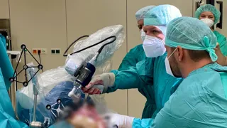 Ärzte während einer Operation, die unter Einsatz von Roboterchirurgie durchgeführt wird  Ärzte während einer Operation, die unter Einsatz von Roboterchirurgie durchgeführt wird