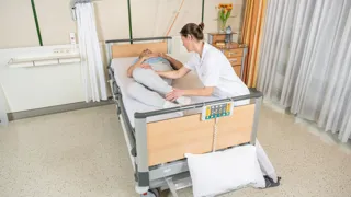REI4043 1044 M105 Im Bett Nach Oben Rutschen Credit Rreichhart Pflegefachkraft hilft Patient dabei im Bett nach oben zu rutschen