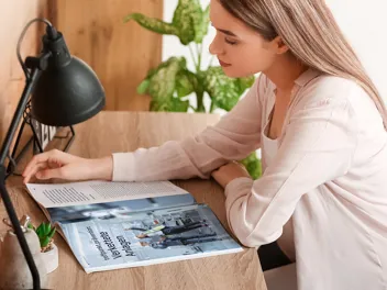 4.5.2_Sichere Arbeit_AdobeStock_408221218_ROI.jpg Junge Frau liest einen Beitrag im AUVA-Magazin „Sichere Arbeit“