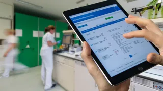 Sicherheitsfachkraft schaut am Tablet das Arbeitsstoffverzeichnis an.